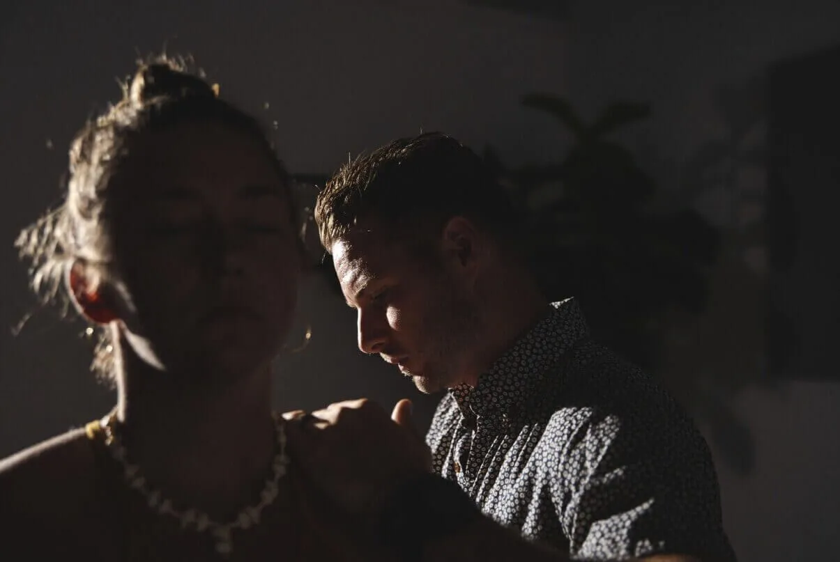 Dr. Tony Miller performing a NetworkSpinal adjustment on a patient in a dimly lit room.