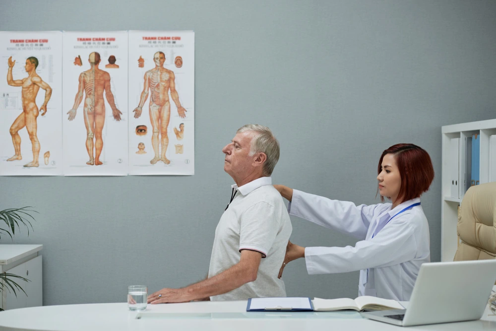 Chiropractor checking patient spine during first chiropractic consultation