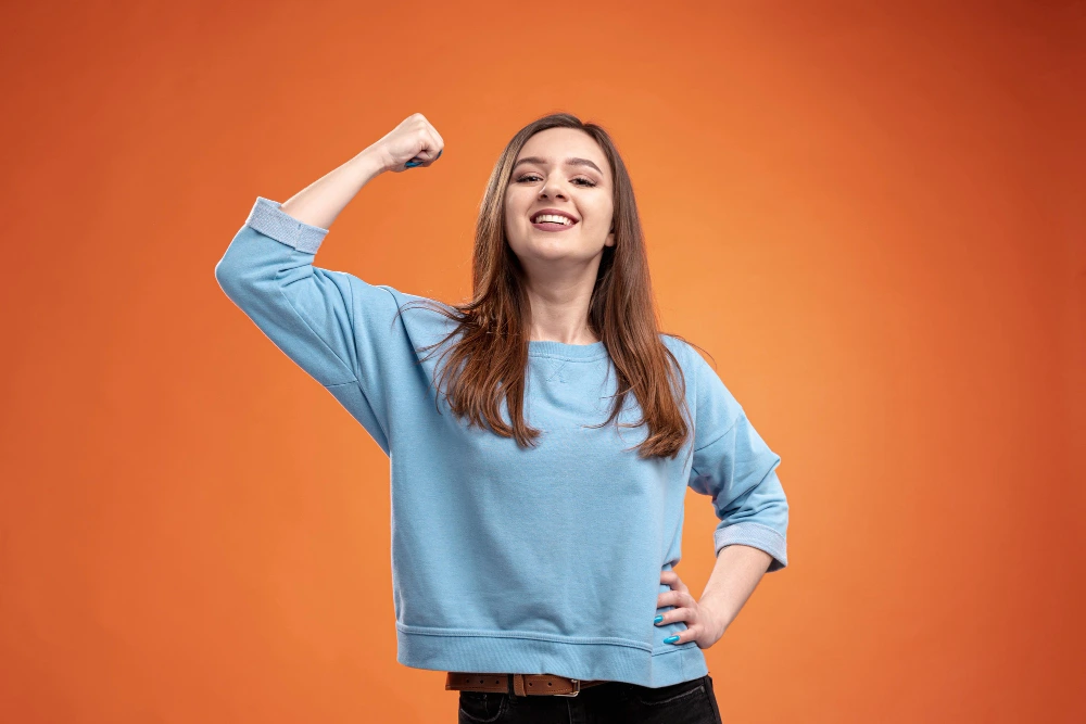 Strong woman flexing arm muscles representing immune strength and wellness