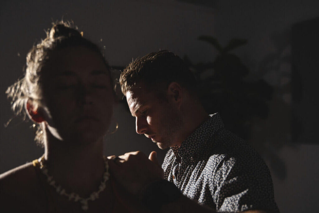 Dr. Tony Miller performing a NetworkSpinal adjustment on a patient in a dimly lit room.