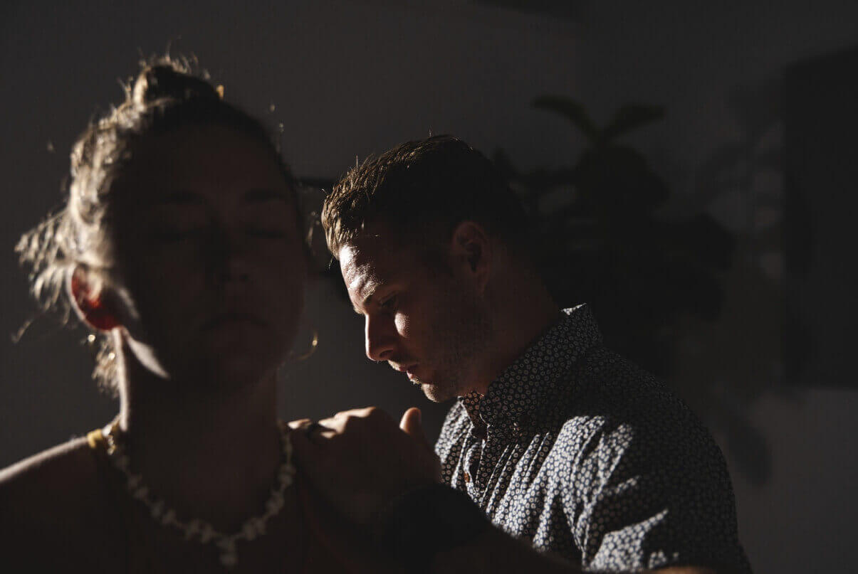 Dr. Tony Miller performing a NetworkSpinal adjustment on a patient in a dimly lit room.