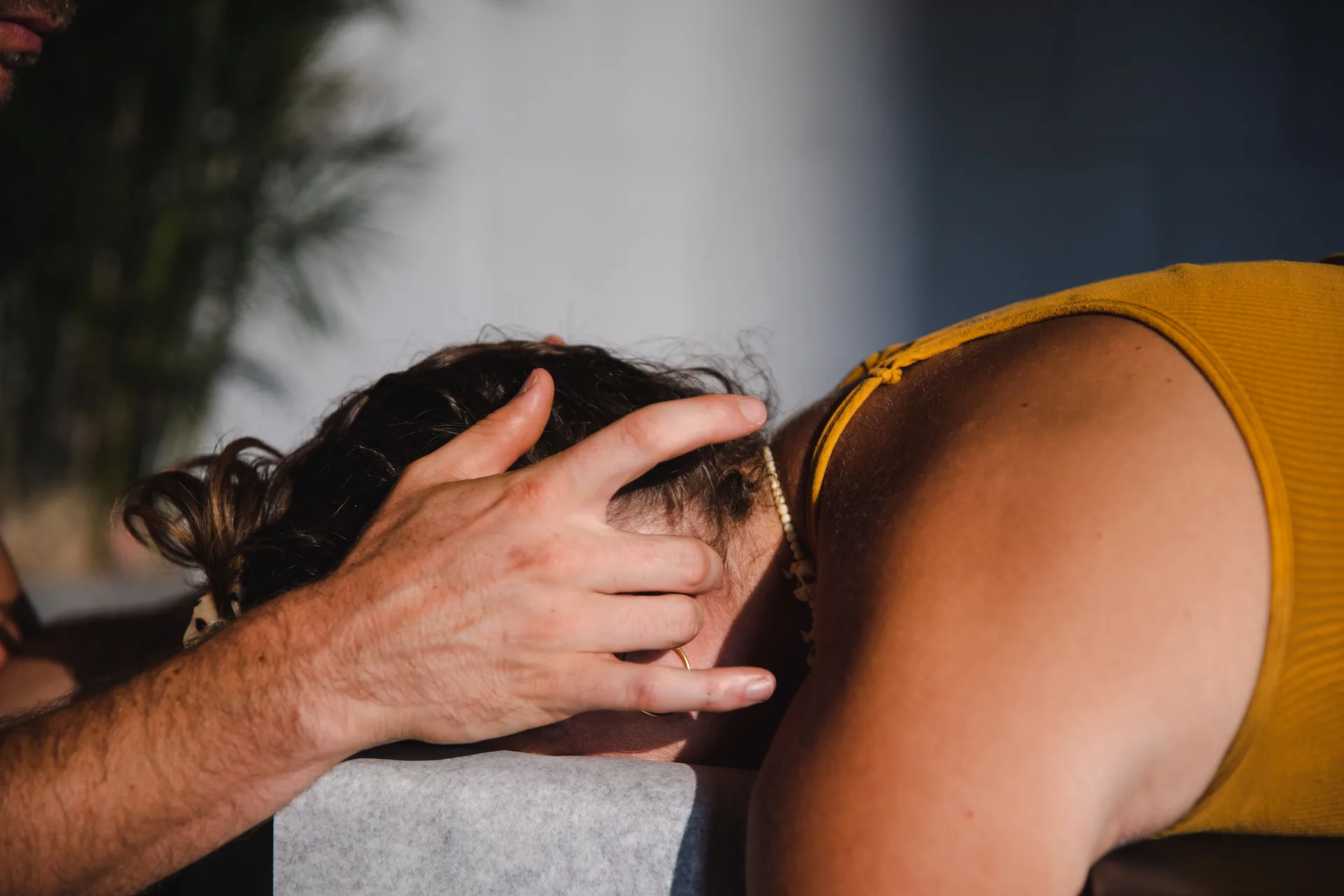 Dr. Tony-Miller, chiropractor specializing in life potential, gently adjusts a patient’s neck during a chiropractic session, highlighting a calm and healing environment.