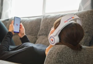 Female wearing BrainTap headset checking NeuralChek assessment for brain stress tracking