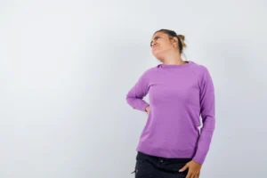 Lady suffering from backache in wool blouse and looking tired