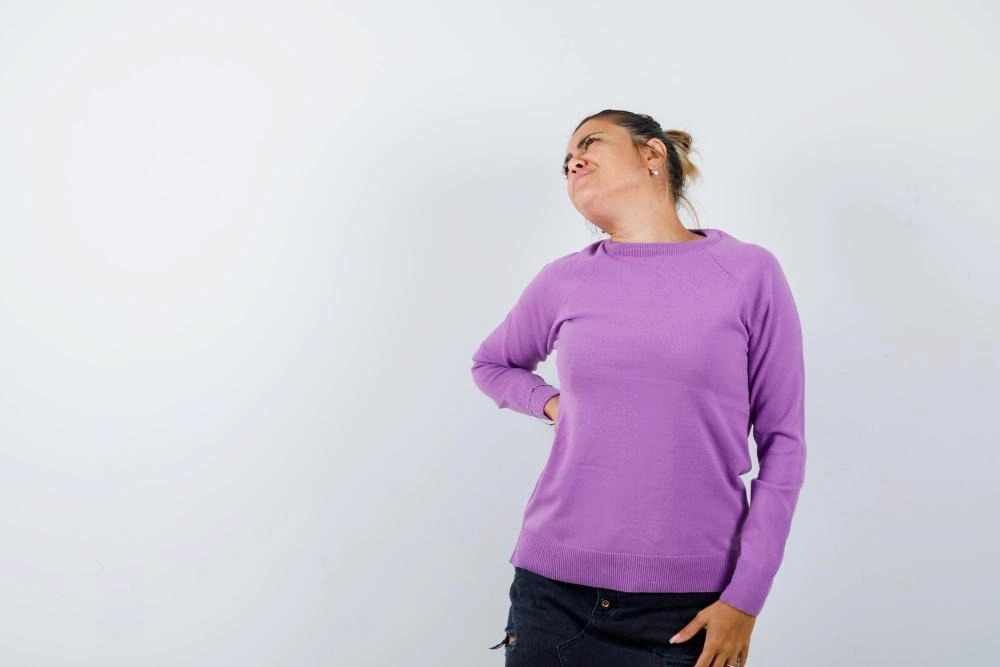 Lady suffering from backache in wool blouse and looking tired