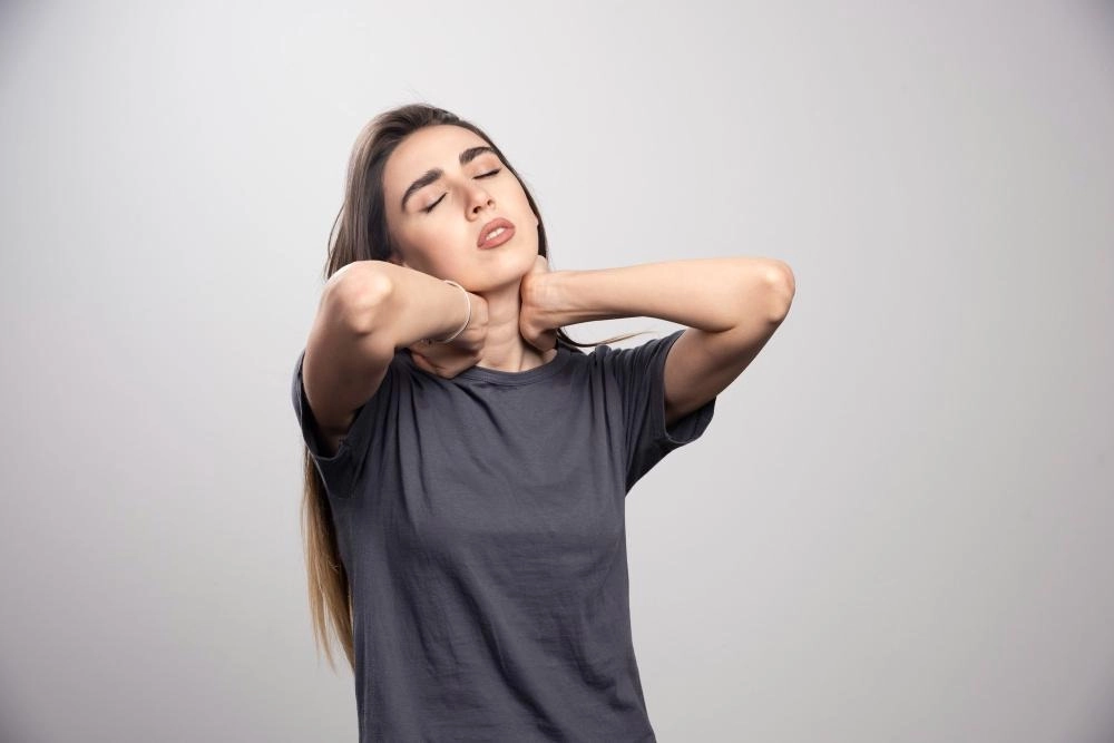 Young woman touching her neck due to pain