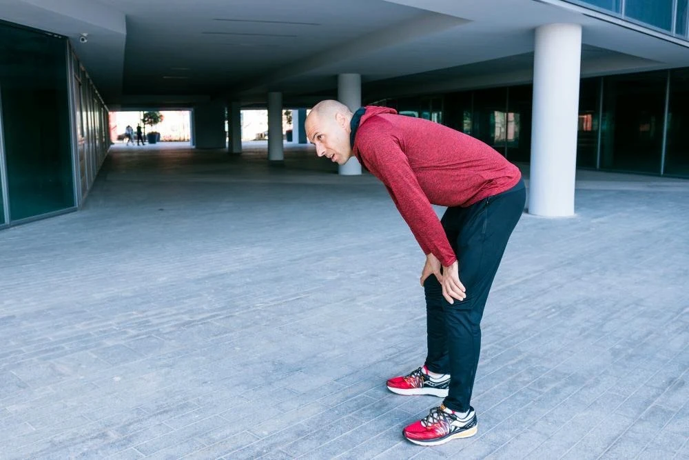 Tired man runner taking a rest after running hard