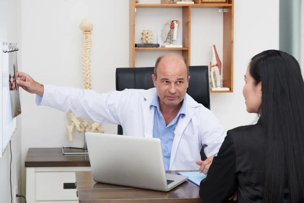 Patient consulting chiropractor during first visit at chiropractic clinic