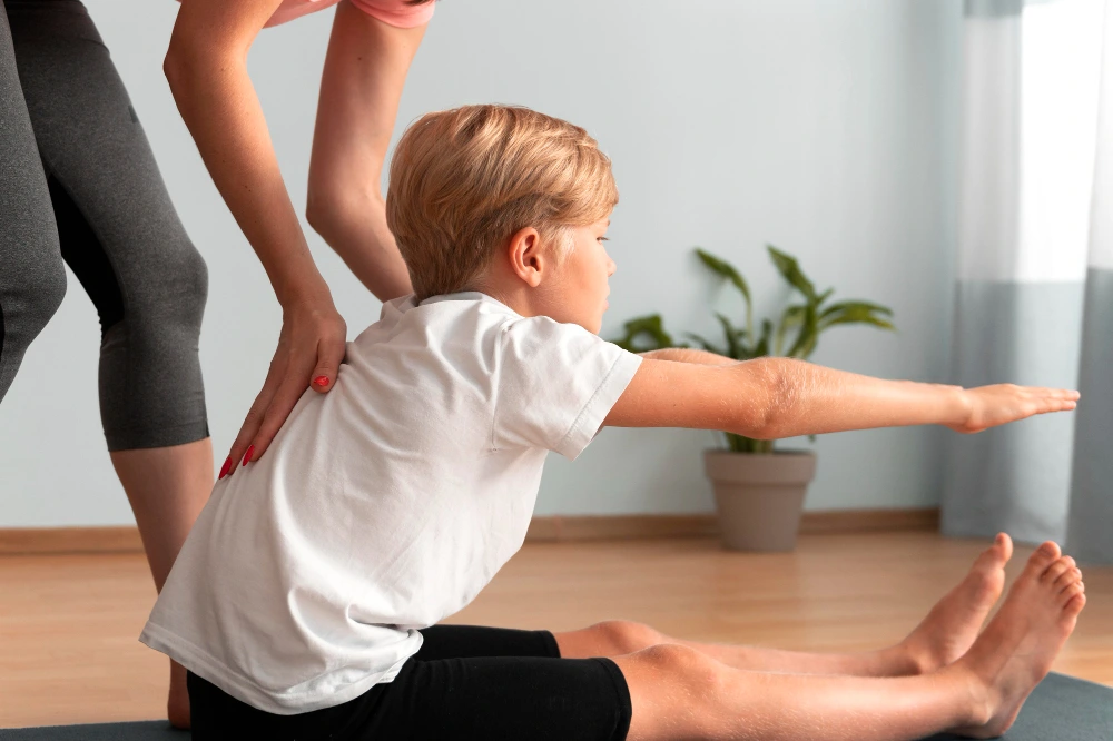 Chiropractor examining spinal alignment of a young boy for scoliosis treatment