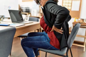 Person experiencing recurring lower back pain and discomfort