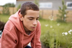 Teenager sitting alone looking tired, stressed, or emotionally overwhelmed