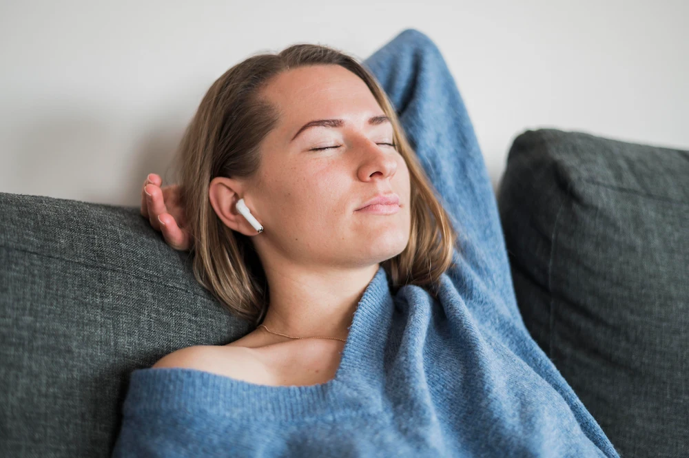 Person relaxing with eyes closed in a calm and peaceful setting