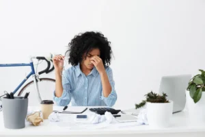 Person sitting at desk looking tired and struggling to concentrate